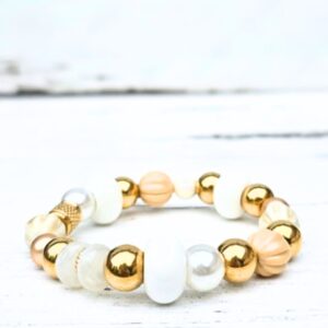Kralenarmband Sandy Glow van Label Six met grote witte en crème kralen en gouden details in beachlife stijl