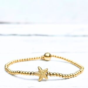 Goudkleurige stainless steel kralenarmband met klein zeesterretje van Label Six