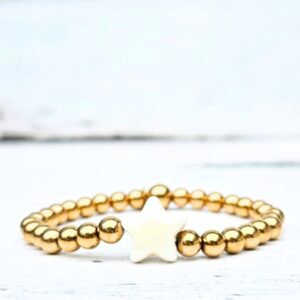 Kralenarmband Sandy Star van Label Six met gouden stainless steel kralen en keramieken crème kleurige ster in beachlife stijl